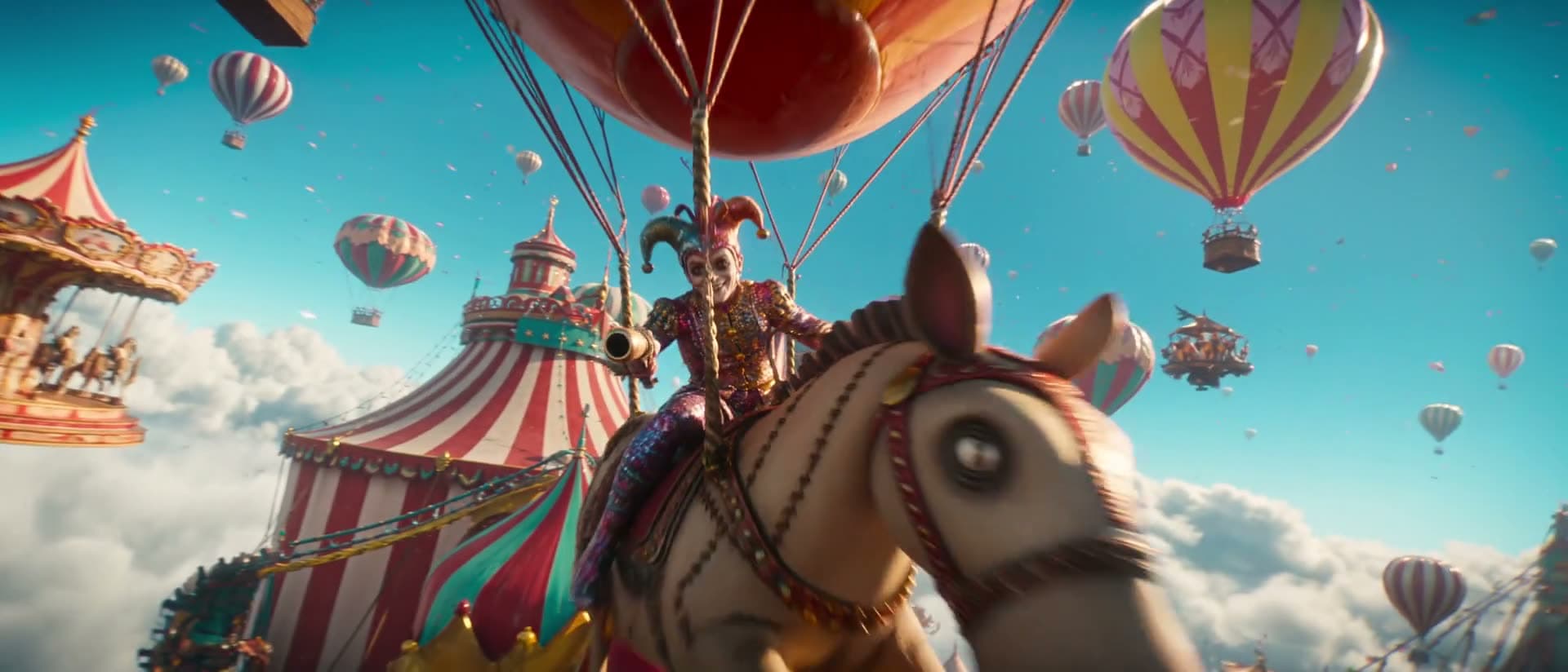 Revelação da tenda em Carnival in the Sky — torres de lona listrada captando luz baixa e quente contra o azul